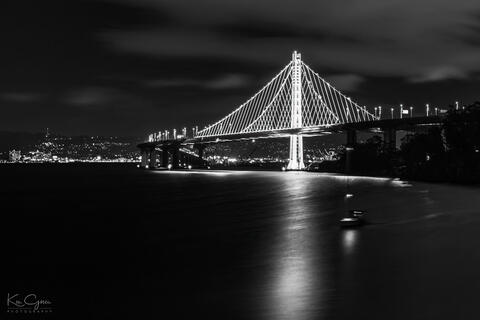 Black and white photo of the eastern span of the San Francisco bay bridge from Treasure Island.