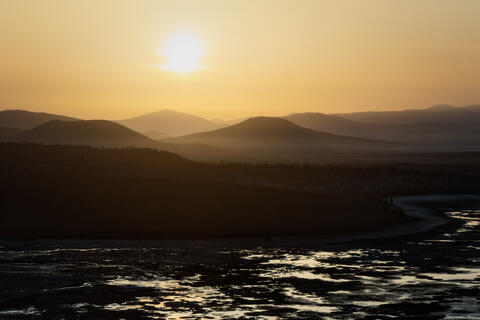 Shasta Cascade region in Northern California at sunrise with layered mountain silhouettes and river valley in the foreground.