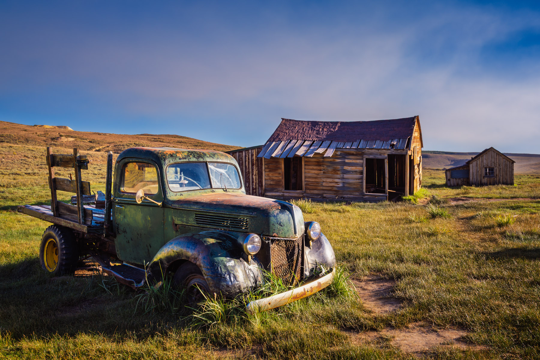 Yesteryear Bodie Historic State Park ghost town in California with abandoned truck near weathered buildings